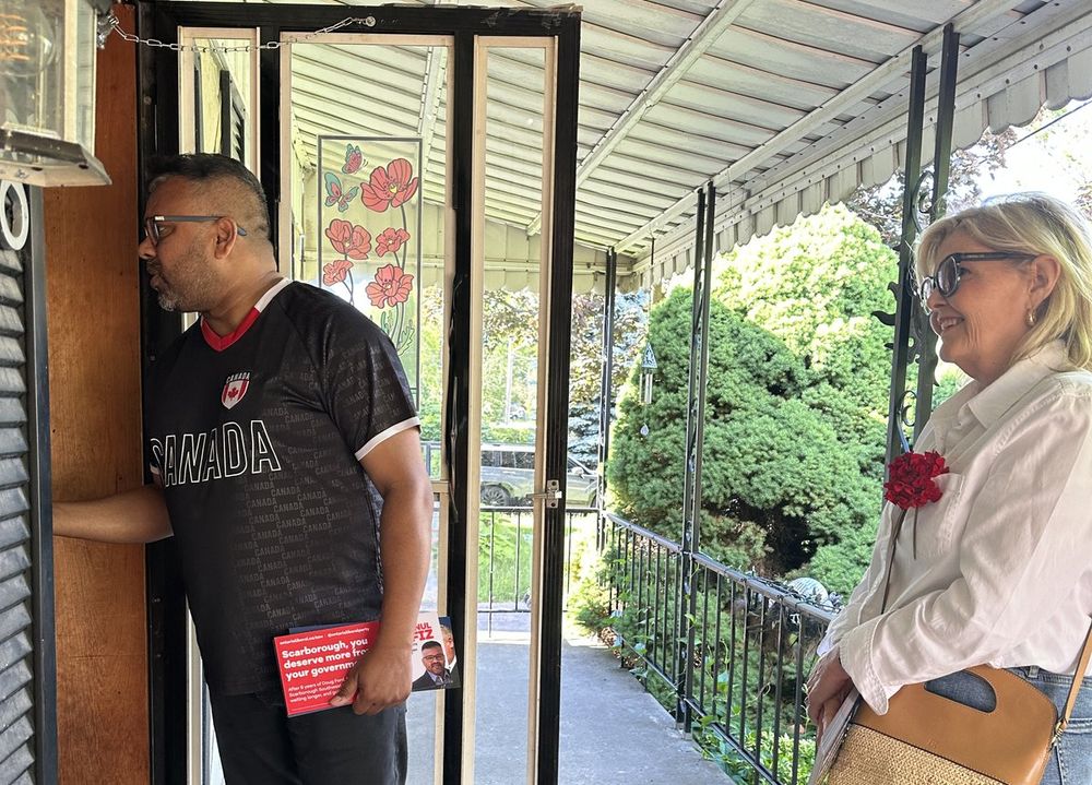 Ahsanul Hafiz at a resident's front door with campaign literature