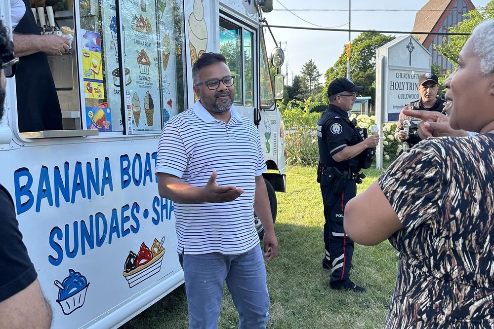 Ahsanul Hafiz talking with neighbours beside an ice cream truck at a community event