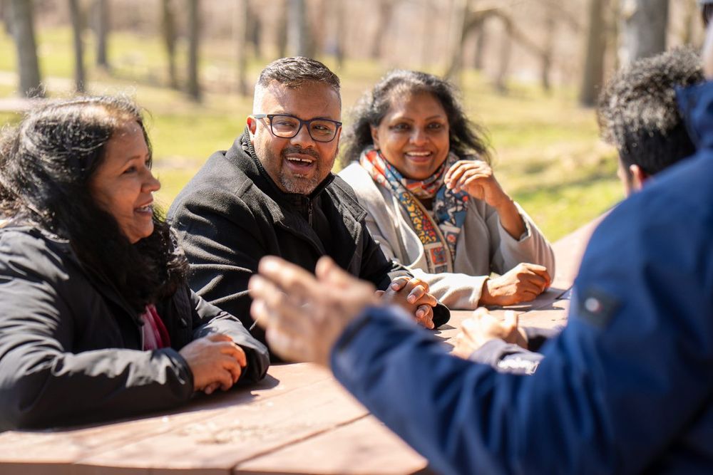 Ahsanul Hafiz laughing with friends around a table