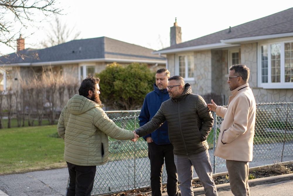 Ahsanul Hafiz greeting neighbours on a driveway while canvassing