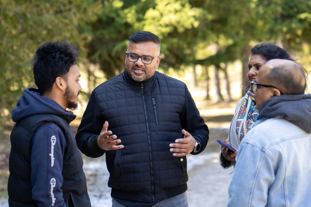 Ahsanul Hafiz speaking with a group of residents outdoors