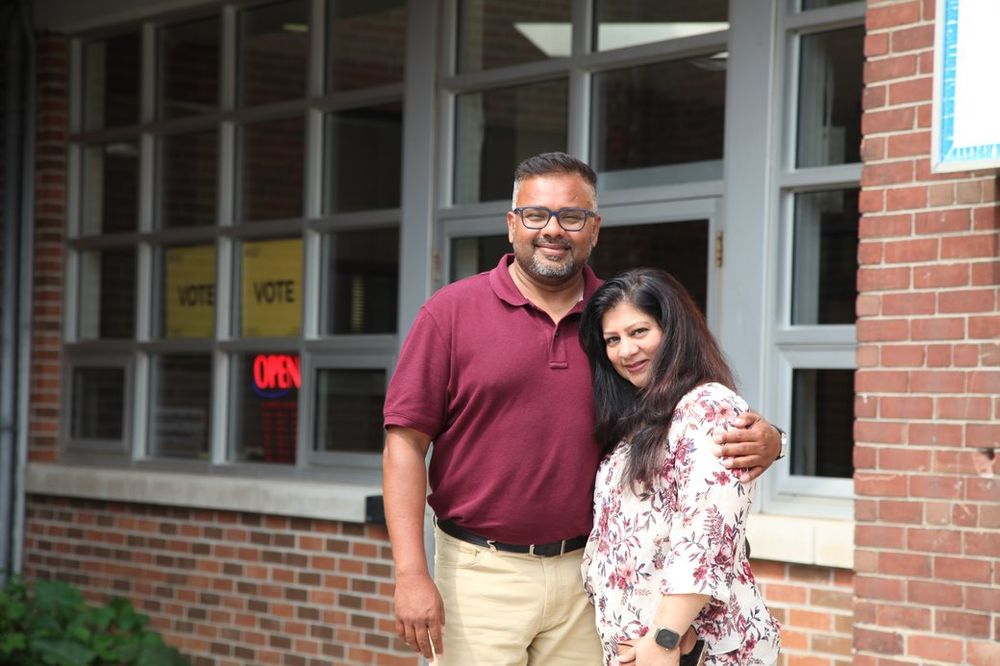 Ahsanul Hafiz with a supporter outside a polling place marked with Elections Ontario vote signs