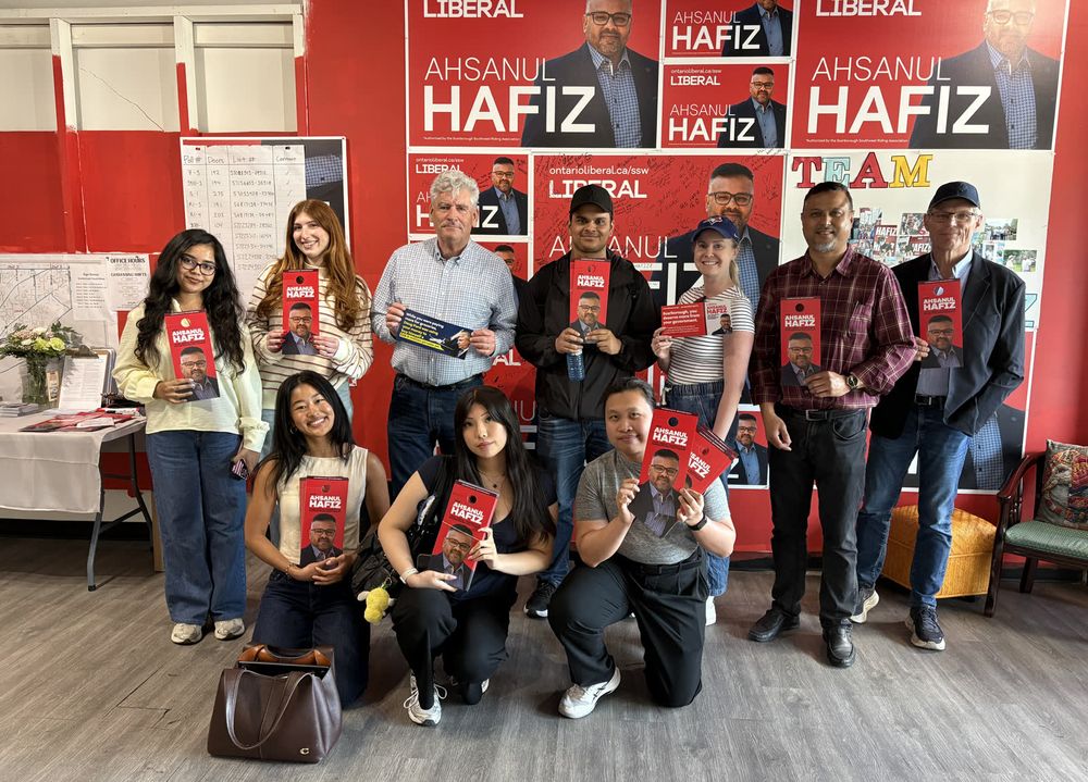 Volunteers packed into the campaign office holding Ahsanul Hafiz signs