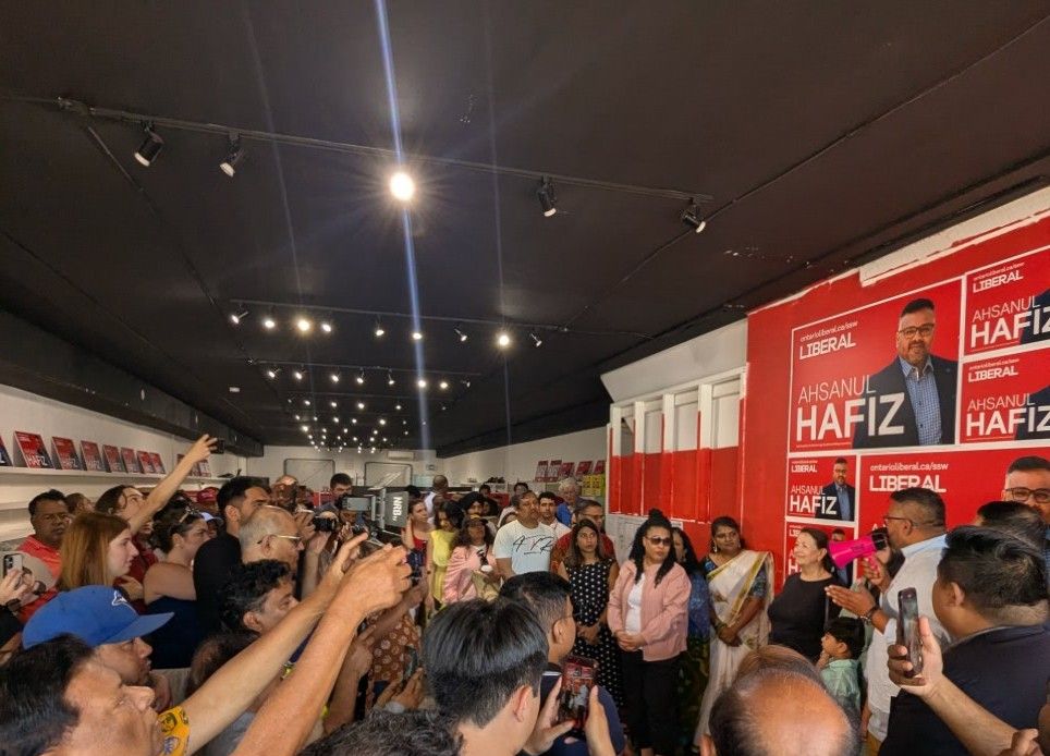 Supporters cheering with raised hands at the campaign office opening