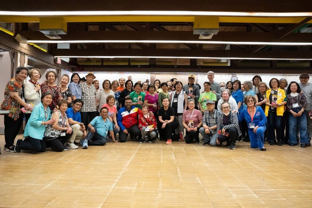 A large group gathered in a community hall at a Filipino seniors event