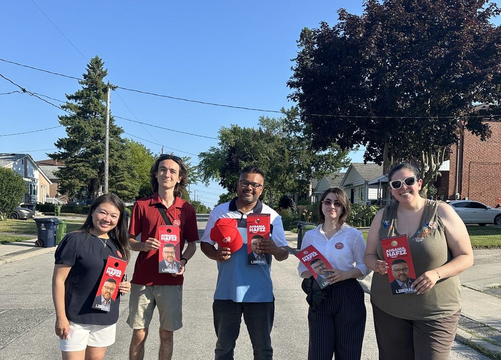 A small team of volunteers with campaign literature on a residential street