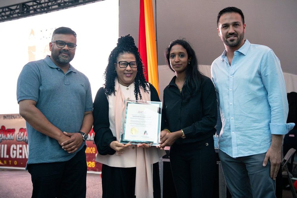 Ahsanul Hafiz with community members holding a framed certificate at a community event